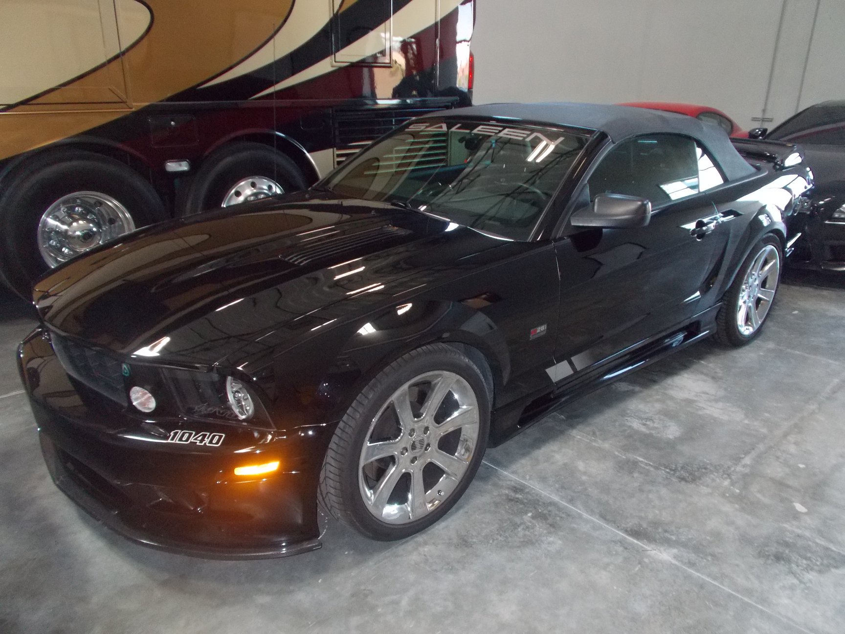 Saleen Mustang convertible stored next to luxury motorcoach